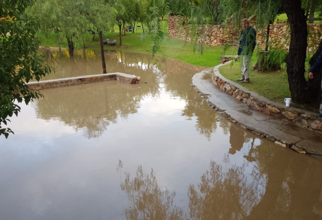 A resort official wearing gumboots inspects the extensive storm damage where muddy floodwaters have submerged the lower recreational grounds of a Western Cape caravan park.
