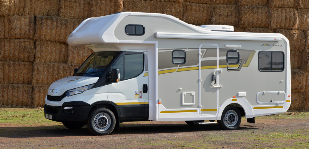 A white luxury Discoverer motorhome built on an Iveco chassis parked in a rural setting